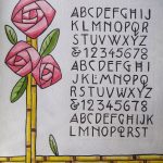 The piece is a full alphabet including numbers in an ornate block letter style, and framed on the left and bottom sides with some bamboo stalks and roses on the top left.