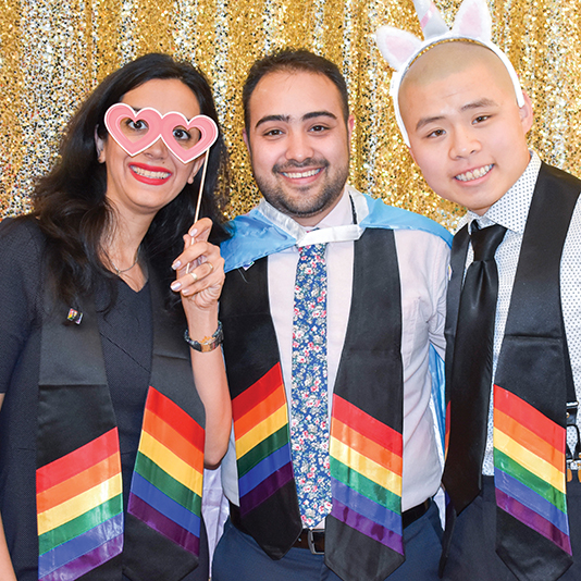 Students at the Pride Graduation wearing rainbow scarves