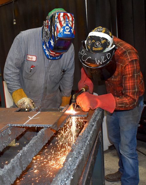 Instructor Scott shows Kevin Hagard welding technique.