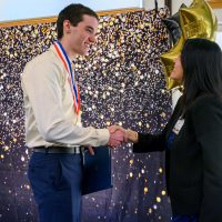 PCC scholar Jesse Hauck receives congratulations from Vice President of Academic Affairs Katy Ho.