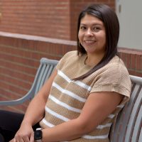 Gabby Garcia sits on bench at SE Campus