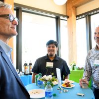 Gongora chatting with former Portland Mayor Sam Adams (left) and Director of College Success Programs Josh Laurie.