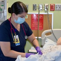 Nursing student works on robot patient