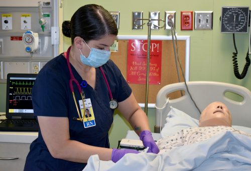 Nursing student works on robot patient