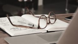 Glasses laid on an open notebook