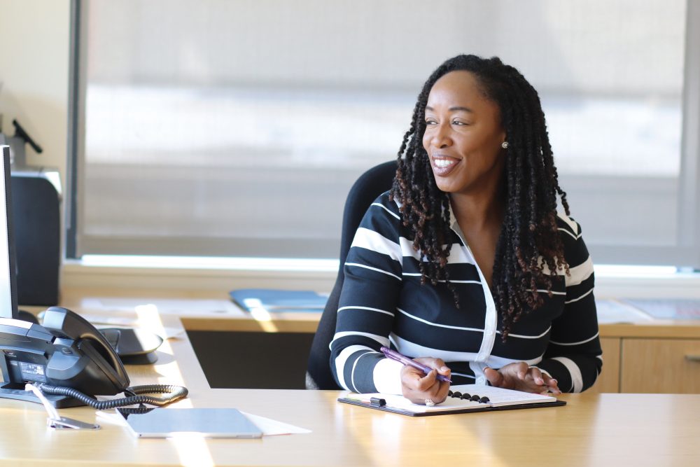 Dr. Adrien Bennings at her desk and looking off to one side