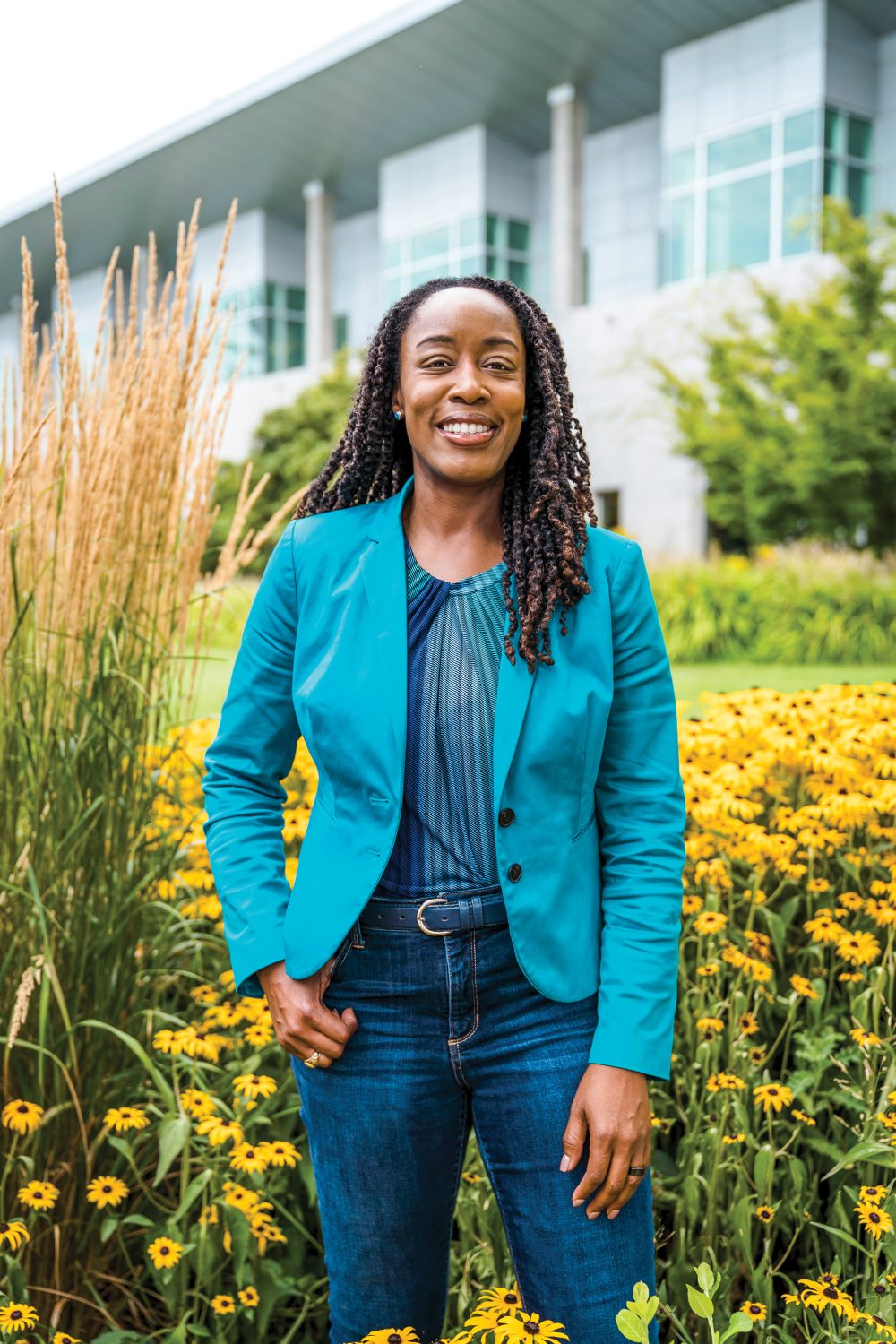 Dr. Adrien Bennings standing outside wearing a PCC turquoise blazer and smiling at the camera