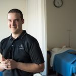 Health care professional Nick Minch standing with clipboard in hospital room