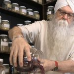 Instructor KP Khalsa stands in herbalism storeroom