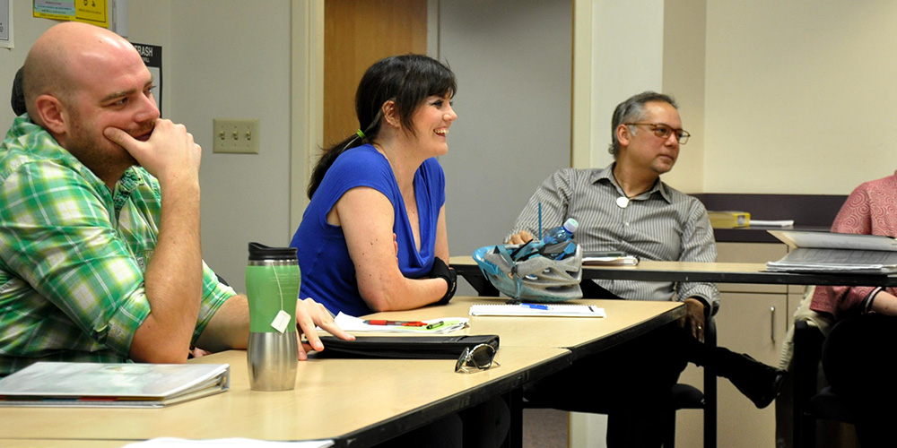 Man and woman sit at table in PCC CLIMB classroom