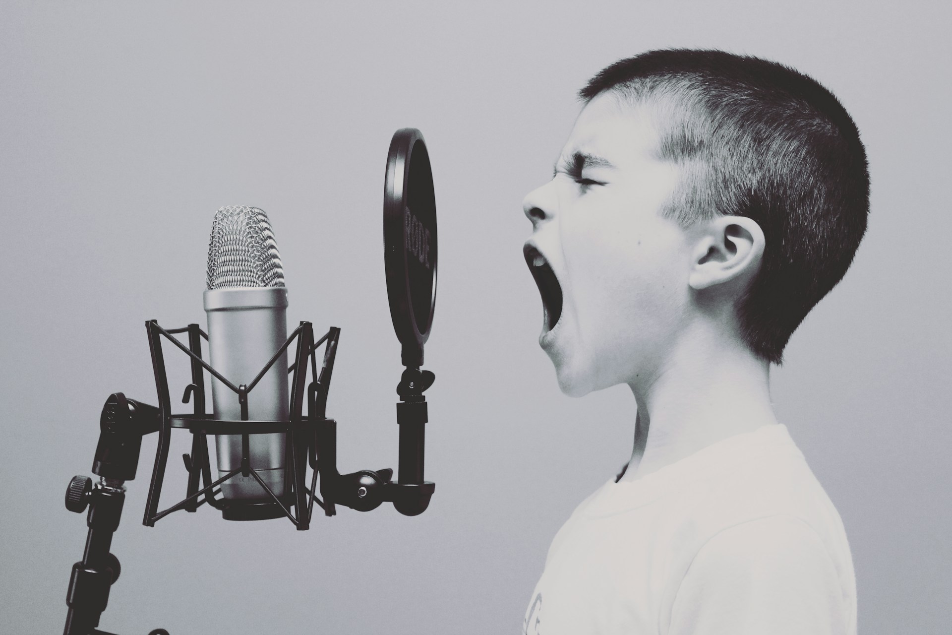 Black and White photo of someone singing into a microphone.