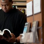 Student reading a book in the library