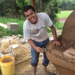 Smiling Person building cob oven