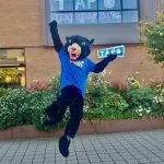 Poppie jumping with Take Back the Tap sign