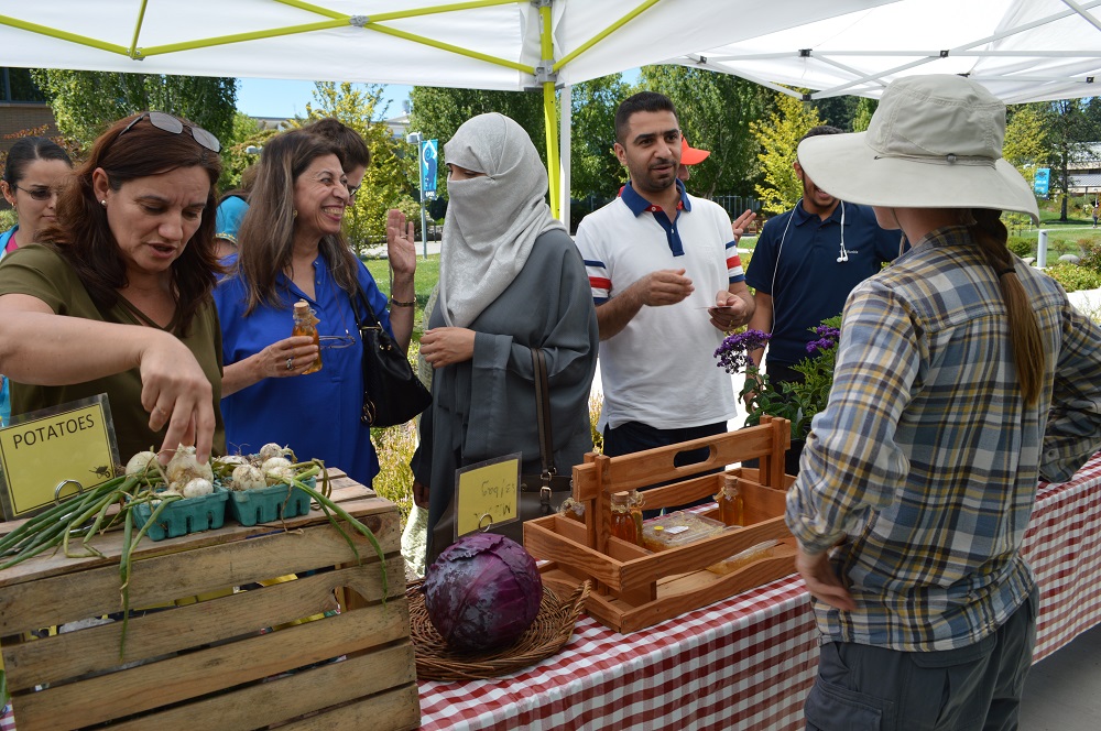 Learning Garden produce stand with people talking
